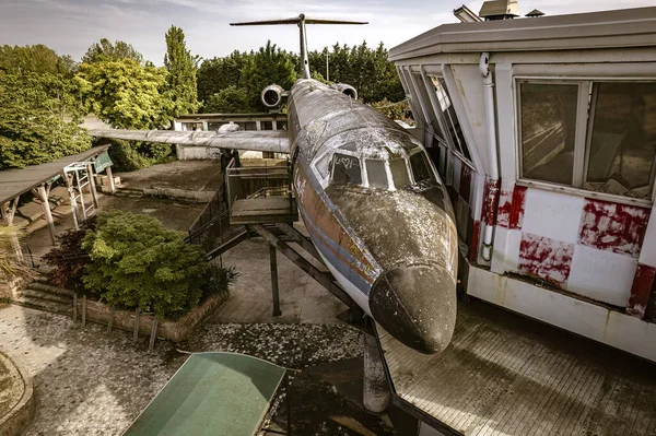 使い捨てのコントロールタワーの近くに眠っている放棄された飛行機の狩猟のイメージは 不気味な雰囲気を捉えます — ストック写真