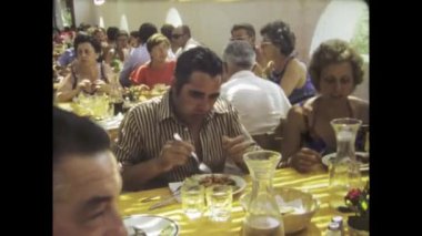 Roma, İtalya 1975 olabilir: 70 'lerden kalma kalabalık bir restoran sahnesinin coşkulu atmosferine dalın, dönemin canlı yemek kültürünü yakalayın.