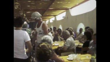 Roma, İtalya 1975 olabilir: 70 'lerden kalma kalabalık bir restoran sahnesinin coşkulu atmosferine dalın, dönemin canlı yemek kültürünü yakalayın.