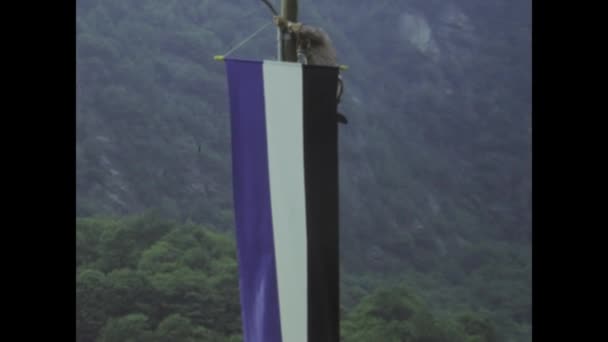 イタリア ベリンツォーナ1975年5月 勇敢な男がこの魅惑的なヴィンテージ映像で旗を掲揚するためにポールを登るとしてアドレナリンで満たされた瞬間を体験する — ストック動画