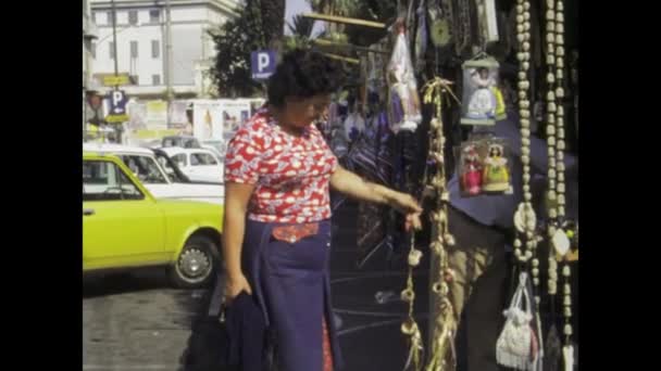 ナポリ イタリア1975年5月 女性がお土産の屋台の活気ある雰囲気に身を浸し 地元の文化の本質を捉えながら 1970年代のナポリにタイムトラベル — ストック動画