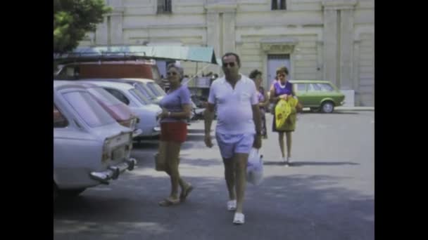 1975年7月イタリア ファノ 高齢者が買い物袋で通りを移動する1970年代の活気ある消費文化を体験する — ストック動画