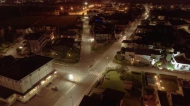 Gece vakti bir şehrin yüksek hızda çekilmiş görüntüsü aydınlanmış sokakların ağını gösteriyor..