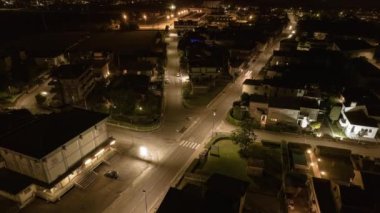 Gece vakti bir şehrin yüksek hızda çekilmiş görüntüsü aydınlanmış sokakların ağını gösteriyor..