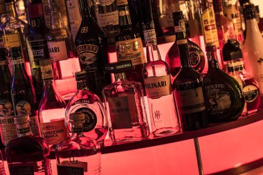 Masi, İtalya 7 Haziran 2023: Bir bar rafında düzenlenmiş çeşitli içki şişeleri, geniş bir ruh yelpazesi sergiliyor.