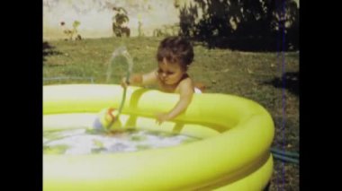 Cernia, İtalya Haziran 1970: 70 'lerde şişme havuzda oynayan bir çocuğun Retro görüntüleri.