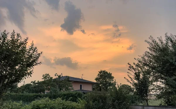 息をのむような夕日の間に空を渡って鮮やかなオレンジ色の壮大なディスプレイ — ストック写真