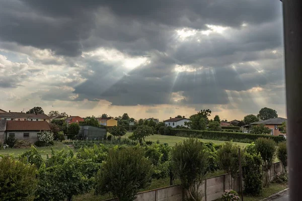 Ηλιαχτίδες Που Διαπερνούν Σύννεφα Φωτίζοντας Ένα Γαλήνιο Χωριό Της Υπαίθρου — Φωτογραφία Αρχείου