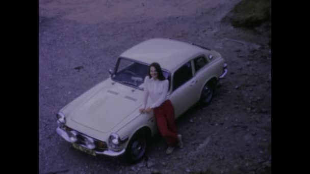 1966年3月 ロンドン イギリス 1960年代の古典的なスポーツカーでポーズする若い女性のヴィンテージ映像を元に戻る — ストック動画