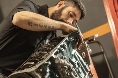 Milan, İtalya 23 Ekim 2023: Bir tamirci klasik bir motoru özgün ihtişamına göre titizlikle tamir eder ve restore eder.