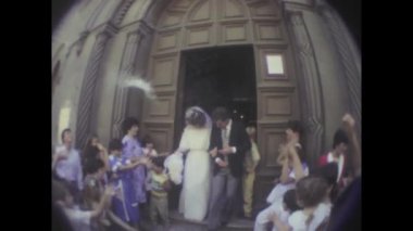 Palermo, İtalya Temmuz 1984: 1980 'lerden neşeli yeni evli bir çiftin düğünlerinden sonra kiliseden çıkışının görüntüleri.