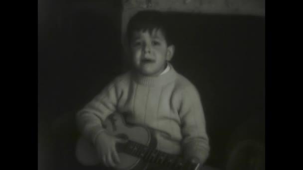 1968年12月イタリアのラヴィニオ 懐かしい黒と白で撮影された1960年代にギターを弾く子供のヴィンテージ映像 — ストック動画