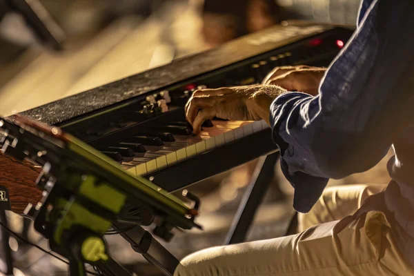 Close-up of a pianist\'s hands playing passionately in a foggy and atmospheric night concert.