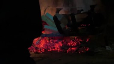 Sıcak bir şöminede yanan parlak alevlerin samimi görüntüsü.