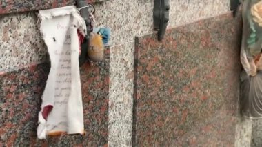 Bulutlu bir günde mezarlıkta bir mezar taşına el yazısıyla ithaf edilmiş bir yaprağın dokunaklı görüntüleri..