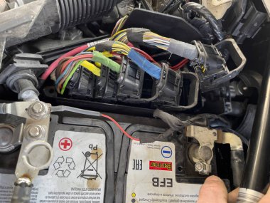 Milan, İtalya 11 Ocak 2024: Motor bölümündeki arabanın motor kontrol ünitesine (ECU) bağlı kabloların yakın çekimi.