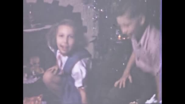 1949年12月アメリカ合衆国シカゴ 暖かい1940年代の家族がアメリカのリビングルームに集まり クリスマスにプレゼントを交換し 喜びに満ちた — ストック動画