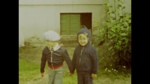 1970年6月のポーランドワルシャワ ポーランドの庭で犬と遊ぶ子供たちのヴィンテージ70Sの映像は ケアフリーの喜びを象徴しています — ストック動画