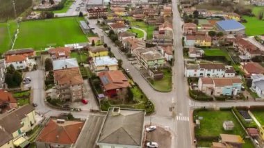 İnsansız hava aracı İtalya 'nın Po Vadisi' ndeki küçük bir kasabanın havadan bakış açısını yakalıyor. Kasaba, kuş bakışı manzaralı yerleşim yerlerini gösteren sıra sıra evlerle dolu..