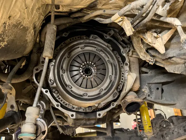 Close-up of a disassembled clutch on a car engine, symbolizing maintenance work.