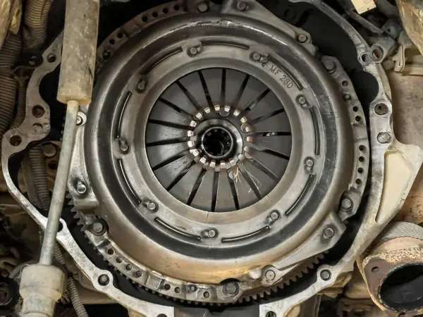 Close-up of a disassembled clutch on a car engine, symbolizing maintenance work.