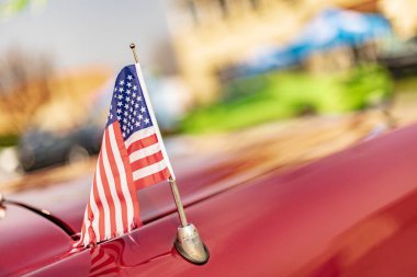 Vicenza, İtalya 19 Mart 2024: Canlı kırmızı bir arabanın kaputuna Amerikan bayrağı asılmış.