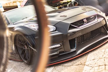 Vicenza, Italy 19 March 2024: Elaborately tuned black Nissan GTR on display at a car show. clipart