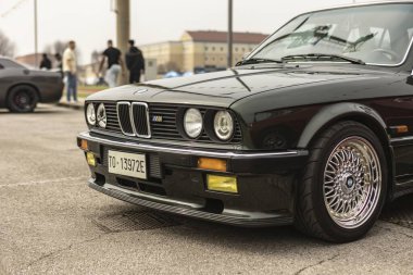 Vicenza, İtalya 19 Mart 2024: Siyah bir BMW aracı diğer boş park yerleriyle çevrili, belirlenmiş bir park yerinde park edilmiş durumda..