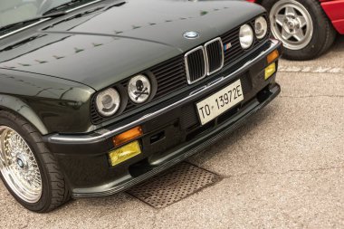 Vicenza, İtalya 19 Mart 2024: Siyah bir BMW aracı diğer boş park yerleriyle çevrili, belirlenmiş bir park yerinde park edilmiş durumda..