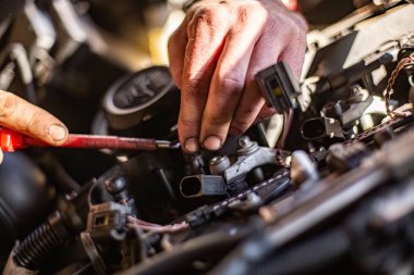 Milan, İtalya 9 Nisan 2024: Bir araba motorunu tamir ederken bir tamircinin kirli ellerine yakın çekim yapmak, çok çalışmanın göstergesi.