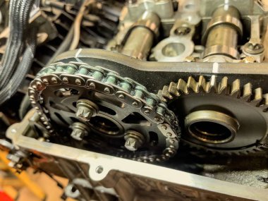 Bir araba motorunun içindeki zamanlayıcı zincirinin yakın görüntüsü.