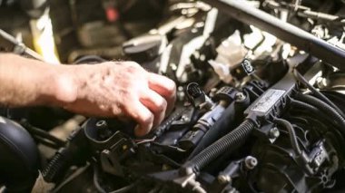 Motordan dizel motor enjektörünü çıkaran yetenekli bir tamirci..