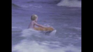 New Orleans, Amerika Birleşik Devletleri 1975: Çocukların kumsalda mutlu anların tadını çıkardıkları, 1970 'lerde neşeli ve neşeli aile anılarını yakalayan şişme bir salın olduğu klasik görüntüler.