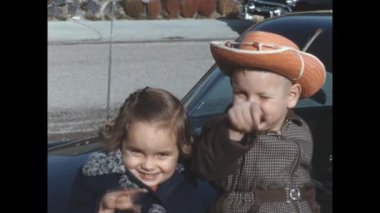 San Diego, Amerika Birleşik Devletleri, Haziran 1955: 1950 Bir arabanın kaputunda oturan sevimli kız ve erkek kardeşler, nostaljik klasik görüntülerde yakalandılar..