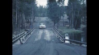 Big Springs, Birleşik Devletler Haziran 1955: 1950 'ler Amerikan arabası bir ormanda köprüden geçerken nostaljik klasik görüntülerde yakalandı..