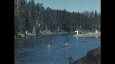 Big Springs, Birleşik Devletler Haziran 1955: 1950 'ler balıkçıları, balıkçılık faaliyetlerini gösteren nostaljik vintage görüntülerde çekilen bir derede dururken çubuk kullanıyorlar..