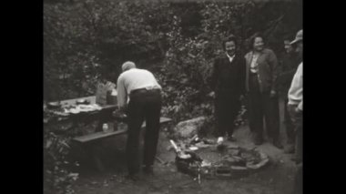 San Diego, Birleşik Devletler 1955: 1950 'lerde bir grup insanın Amerika' da bir ormanın ortasında barbekü hazırlarken nostaljik vintage tarzında yakalandığı görüntüler..