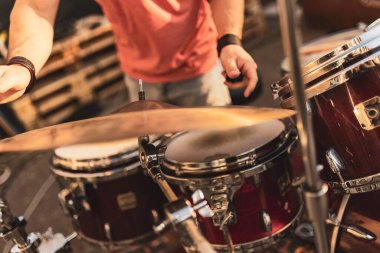 Açık hava etkinliği sırasında arka planda bulanık bir davulcunun davul çalarken yakın plan görüntüsü.