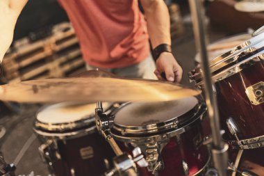 Açık hava etkinliği sırasında arka planda bulanık bir davulcunun davul çalarken yakın plan görüntüsü.