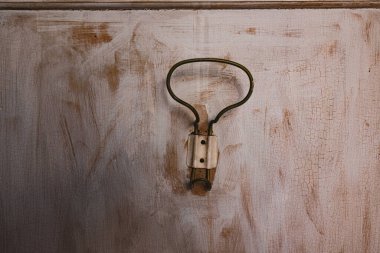 Paslı bir duvara asılan kancayı yıpranmış bir kapıya iliştirmiş, yaşını ve karakterini gösteriyor..