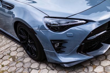 Gavello, Italy 23 june 2024: A sleek grey Toyota GT86 parked on a cobblestone street with greenery on the side clipart