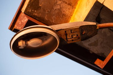 Milan, İtalya 7 Temmuz 2024: Kırsal ve endüstriyel görünümlü eski, yıpranmış bir sokak lambasına yakın çekim.