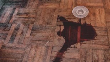 Tahta zemindeki kağıt bardaktan dökülen bir içecek fark edilebilir bir leke yaratır..