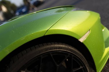 Adria, İtalya 30 Temmuz 2024: Yeşil bir Lamborghini ön çamurluk ve tekerleğin su damlacıklarıyla yakın çekimi