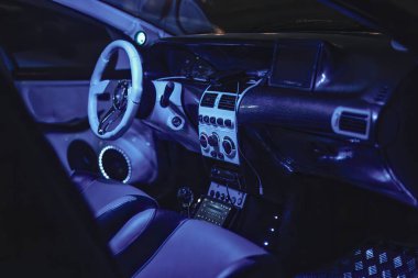 Adria, İtalya 30 Temmuz 2024: Gelişmiş teknoloji ve mavi çevre aydınlatmalı, modern otomotiv tasarımı sergilenen fütüristik bir araba iç mimarisi.