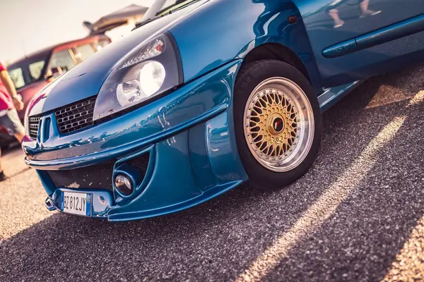 stock image Adria, Italy 30 july 2024: Close-up front view of a blue Renault Clio showcasing its custom bumper and golden wheels.