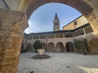 Badia Polesine İtalya 'da merkezi bir kuyu ve çan kulesinin yer aldığı tarihi manastır avlusu Vangadizza