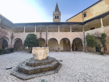 Badia Polesine İtalya 'da merkezi bir kuyu ve çan kulesinin yer aldığı tarihi manastır avlusu Vangadizza