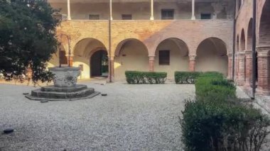 Badia Polesine İtalya 'da merkezi bir kuyu ve çan kulesinin yer aldığı tarihi manastır avlusu Vangadizza