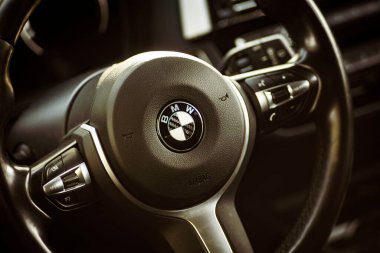 Milan, İtalya 28 Ağustos 2024: Şık kontrollü BMW direksiyon simidine odaklanan iç çekim.